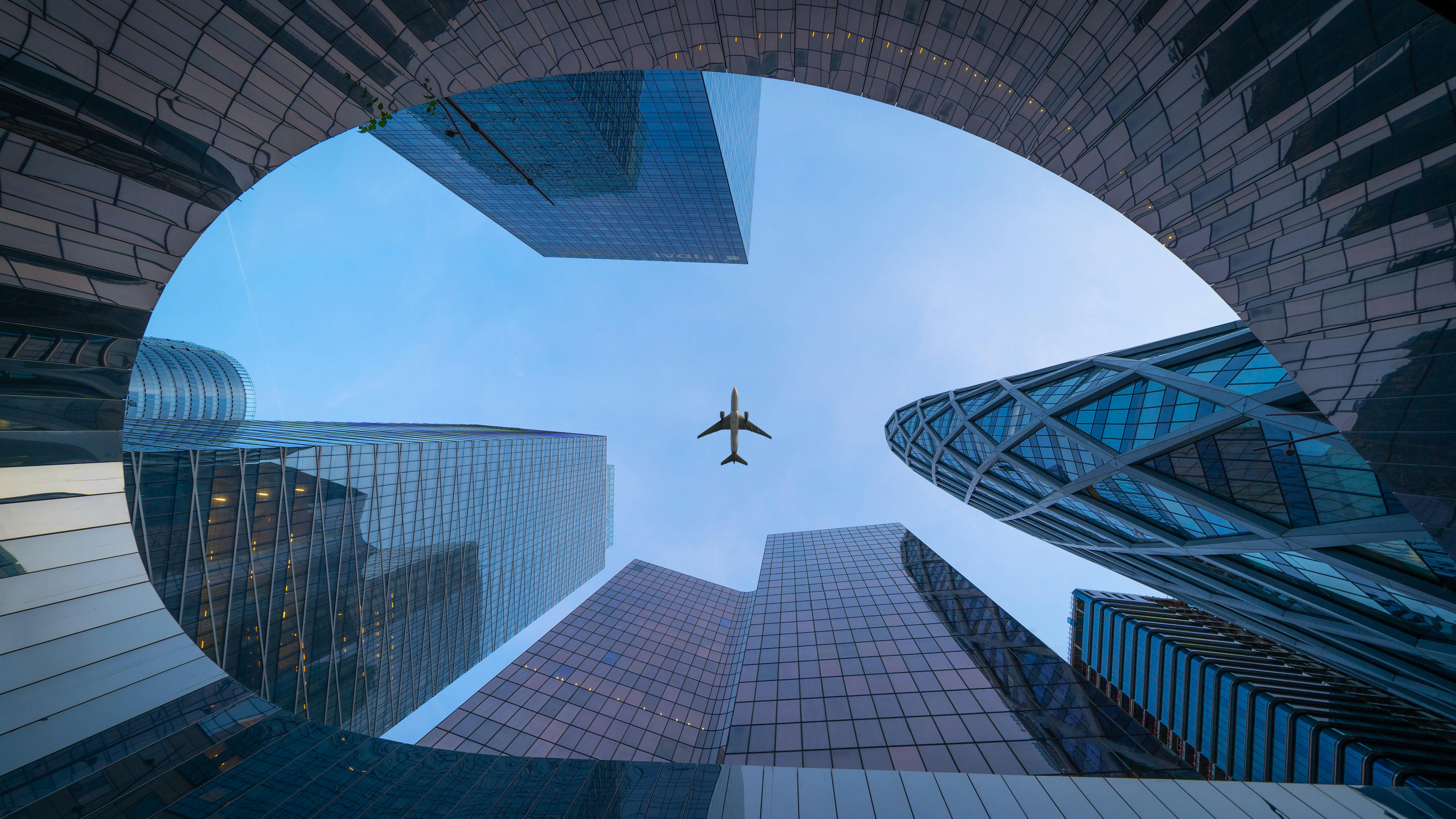 Airplane over corporate skyscrapers
